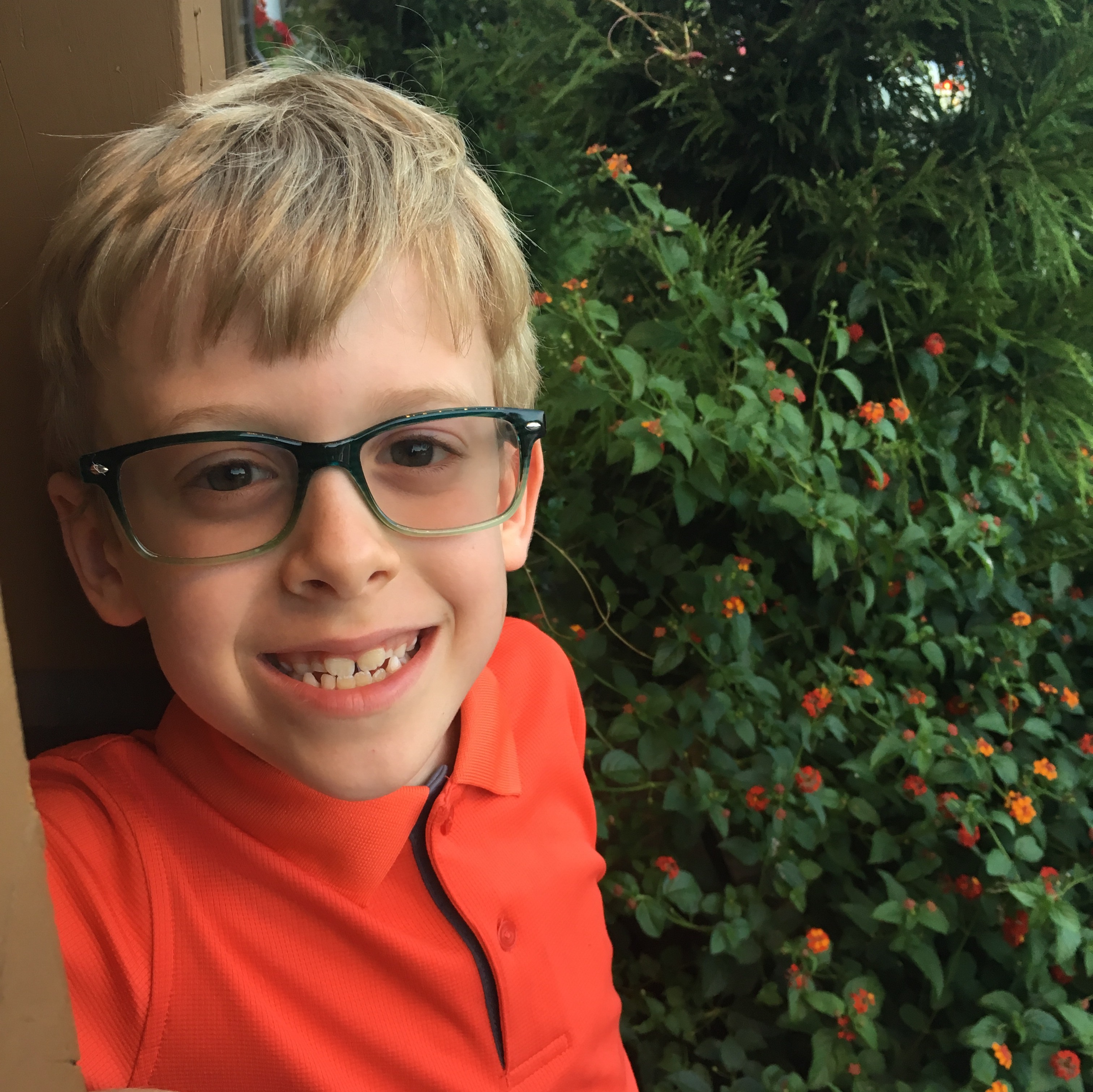image of young boy wearing eyeglasses outside